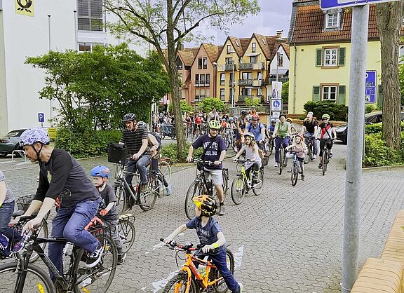 Kinder und Erwachsene fahren auf Fahrrädern durch die Stadt